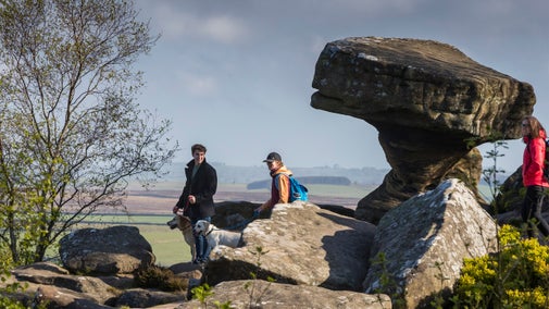 Visitors walking around the base of the Druids Writing Desk Rock